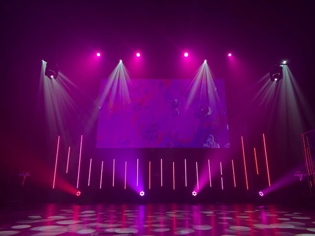 ピンクの照明にに照らされているステージ