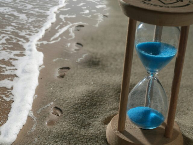 波打ち際に置かれた青い砂時計