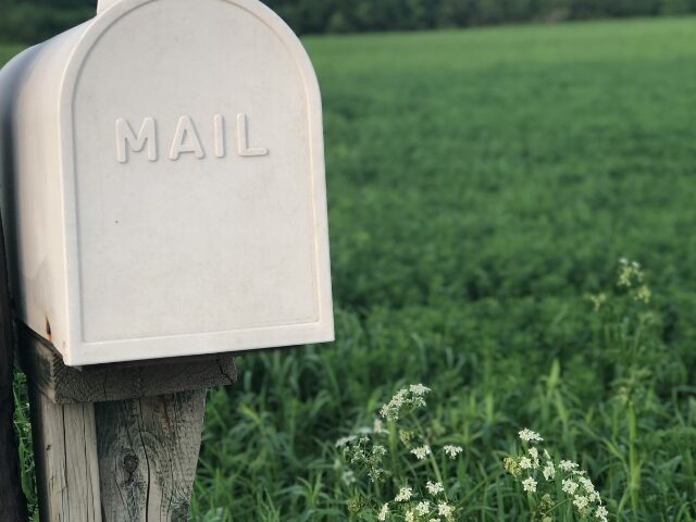 草原に置いてある白いメールボックス