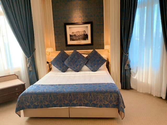青い柄の枕が3つ並んでいるホテルのベッド