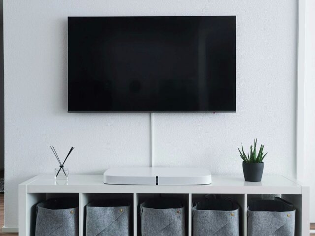 白い壁に置かれているテレビとテレビ台