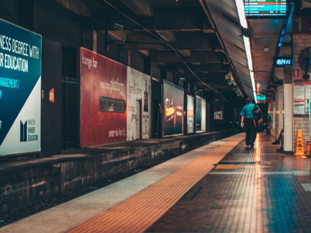 誰もいない駅のホームを歩いている男性