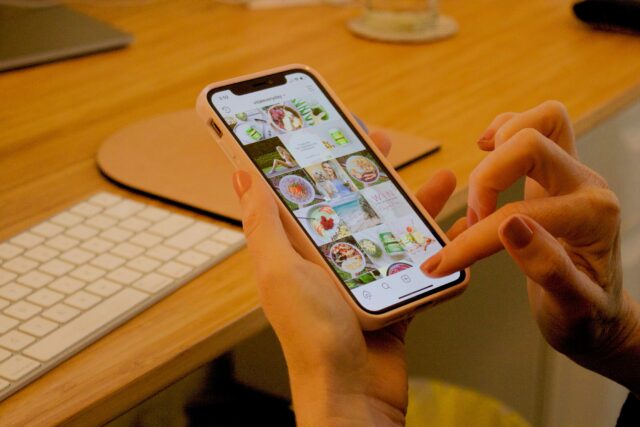 スマホでインスタをチェックする女性の手