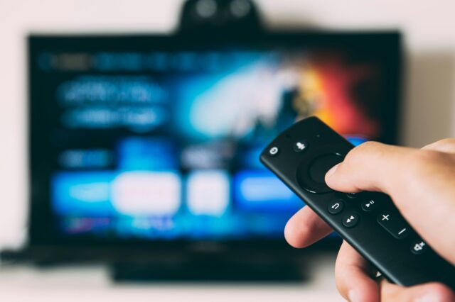 リモコンでテレビ画面を操作している
